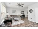 Cozy living room with a ceiling fan, gray sofa, and stylish decor at 19613 Feriba Pl, Cornelius, NC 28031
