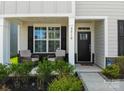 Inviting front porch with seating area, decorative pillars and manicured landscaping at 2010 Saddlebred Dr, Iron Station, NC 28080