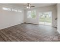 Bright, open-concept living room with contemporary floors, large windows, and a sliding glass door to the backyard at 2591 Watson Dr, Lancaster, SC 29720