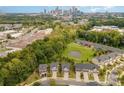 Wide aerial view capturing homes near a pond, lush greenery and the city skyline at 3614 Dolly Madison Rd, Charlotte, NC 28208