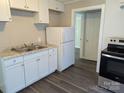 Functional kitchen featuring white cabinets, granite countertops, stainless steel appliances, and sleek flooring at 3703 Crawford St, Gastonia, NC 28052