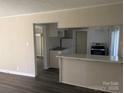 Inviting view of the kitchen with granite countertops, white cabinets, and stainless steel appliances from the living area at 3703 Crawford St, Gastonia, NC 28052