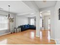 Bright, open-concept living room with hardwood floors, modern chandelier, and a comfortable blue sectional sofa at 3812 Caldwell Ridge Pkwy, Charlotte, NC 28213