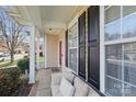 Cozy porch with a cushioned bench seat, white columns, black shutters, and a bright red front door at 3812 Caldwell Ridge Pkwy, Charlotte, NC 28213