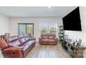 Comfortable living room with leather sofas, wood floors, natural light, and entertainment center at 3870 County Down Ave, Kannapolis, NC 28081