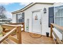 Cozy front porch with welcome mat, wooden railing, and exterior door with black shutters provides a warm greeting at 405 Briarwood Ct, Mount Holly, NC 28120