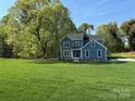 Beautiful two-story home with a large, green front yard and surrounded by mature trees at 522 Fern Hill Rd # 17, Mooresville, NC 28117