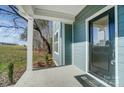 Covered front porch featuring white columns, a blue door, and a welcome mat, offering a charming entry at 522 Fern Hill Rd # 17, Mooresville, NC 28117
