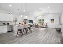 Open-concept kitchen and living area with white cabinets, stainless steel appliances, and modern furnishings at 5824 Patton St, Charlotte, NC 28269