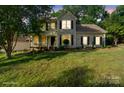 Traditional-style home with a welcoming front porch, dark shutters and a well-maintained front lawn at 6210 Skyline Dr, Charlotte, NC 28269