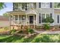 Close up view of a home's covered entrance and front porch with manicured landscaping and walkway at 6210 Skyline Dr, Charlotte, NC 28269