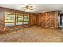 Inviting living room with wood walls, large windows offering natural light and views of the outdoors at 624 Flicker St, Concord, NC 28027