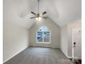 Unfurnished living room with large window, ceiling fan, vaulted ceiling, and neutral gray carpet at 89 Fifth St, York, SC 29745