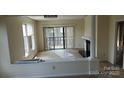 Sunlit living area featuring a fireplace, sliding glass doors to a balcony, and neutral tones throughout at 9035 Jm Keynes Dr # 39, Charlotte, NC 28262
