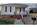 Inviting single-story home with a quaint front porch, brick foundation, and manicured lawn at 915 Spruce St, Albemarle, NC 28001