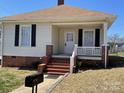 Classic single-story home featuring a welcoming front porch with brick foundation at 915 Spruce St, Albemarle, NC 28001