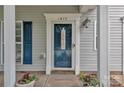 Close-up of front door with decorative details, potted plants and attractive blue shutters at 1017 Chalk Hill Ln, Charlotte, NC 28214