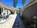 Stone patio with outdoor seating connects the house to a covered porch and landscaped yard at 1112 Avalon Pl, Stallings, NC 28104