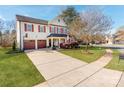 Inviting two-story home with a spacious driveway, lush lawn, and mature landscaping at 12510 Pine Terrace Ct, Charlotte, NC 28273