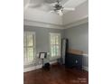 Neutral bedroom with ceiling fan, tray ceiling, hardwood floors, and white shuttered windows at 1308 Moonshadow Ln, Shelby, NC 28150