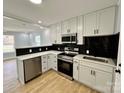 Modern kitchen boasting stainless steel appliances, white cabinets, dark backsplash, and gorgeous granite countertops for cooking and entertaining at 1946 Academy St, Charlotte, NC 28205