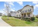 Traditional home with manicured lawn, sidewalk, and covered front porch at 2110 Capricorn Ave, Indian Trail, NC 28079