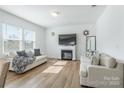 Bright living room with fireplace, neutral sofas, and hardwood floors, perfect for gatherings at 3077 Light Ridge Sw Ct, Concord, NC 28027