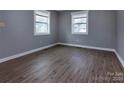 Bright bedroom with wood-look floors, gray walls, and natural light from two windows at 326 Mountain View St, Gastonia, NC 28052