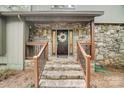 Inviting stone front porch with decorative wreath and wooden railings at 4124 Woodfox Dr, Charlotte, NC 28277