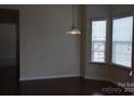 Cozy dining area with hardwood floors, large windows, and a stylish hanging light fixture at 4892 Horseback Ln, Harrisburg, NC 28075