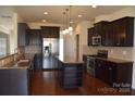 Modern kitchen featuring stainless steel appliances, dark cabinetry, and a center island with granite countertops at 4892 Horseback Ln, Harrisburg, NC 28075