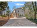 Spacious driveway leading to a home with a covered walkway and freshly painted white brick at 7214 Benita Dr, Charlotte, NC 28212