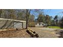 A single story home with neutral siding, mature trees, an outbuilding and gravel landscaping at 816 Osteen Rd, York, SC 29745