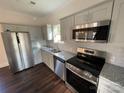 Modern kitchen with stainless steel appliances, granite countertops, gray cabinets, and a stylish tile backsplash at 8704 Moody Rd, Charlotte, NC 28215