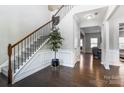 Elegant foyer with a staircase, hardwood floors, and decorative wainscoting leading into the home at 100 Marabou Ct, Mount Holly, NC 28120