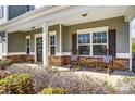 Cozy front porch with rocking chairs, decorative plants, and stone accents, creating a welcoming entrance at 100 Marabou Ct, Mount Holly, NC 28120