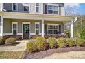 Inviting front porch with decorative plants, stone accents, and comfortable seating, enhancing the home's curb appeal at 100 Marabou Ct, Mount Holly, NC 28120