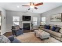 Cozy living room featuring a fireplace, plush seating, and a ceiling fan at 100 Marabou Ct, Mount Holly, NC 28120