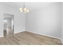 Clean, freshly painted dining room featuring modern light fixture and light laminate flooring at 11331 Breezehill Ln, Charlotte, NC 28262