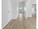 Bright hallway with modern laminate floors, white walls, and natural light from a window at the end at 11331 Breezehill Ln, Charlotte, NC 28262