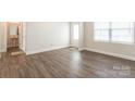 Bright bedroom features wood-look floors, a large window, and neutral paint for a serene atmosphere at 131 Jacobs Hill Pl, Troutman, NC 28166