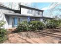 Charming gray home featuring a brick walkway, lush landscaping, and a welcoming blue door at 1793 Fairway Dr, Newton, NC 28658