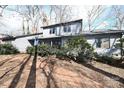 Charming gray home featuring a brick walkway, mature trees, and lush landscaping at 1793 Fairway Dr, Newton, NC 28658