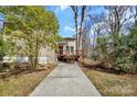 A well-maintained yard leads to the back of the house, featuring a deck and a partial view of the surrounding landscape at 2406 Brook Canyon Dr, Charlotte, NC 28212