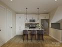 Stylish kitchen with white cabinets, pendant lighting, stainless steel appliances, and a central island with seating at 2436 Arty Ave, Charlotte, NC 28208