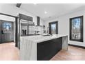 Bright, open kitchen with a large marble island and stainless steel refrigerator at 5501 Joyce Dr, Charlotte, NC 28215