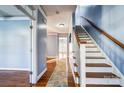 Bright hallway with hardwood floors, a staircase, and neutral paint, creating a welcoming entry space at 5807 Mctaggart Ln, Charlotte, NC 28269
