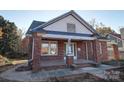 Charming brick home with a covered front porch, showcasing classic architecture and welcoming curb appeal at 610 Hawthorne Ln, Charlotte, NC 28204