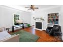 Bright living room featuring hardwood floors, a decorative fireplace, and ample natural light from a large window at 1001 Craven Ave, Kannapolis, NC 28083