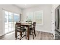 Cozy dining area with wooden table and chairs situated next to sliding glass door and windows at 1032 Barnette Farm Ln, Monroe, NC 28110
